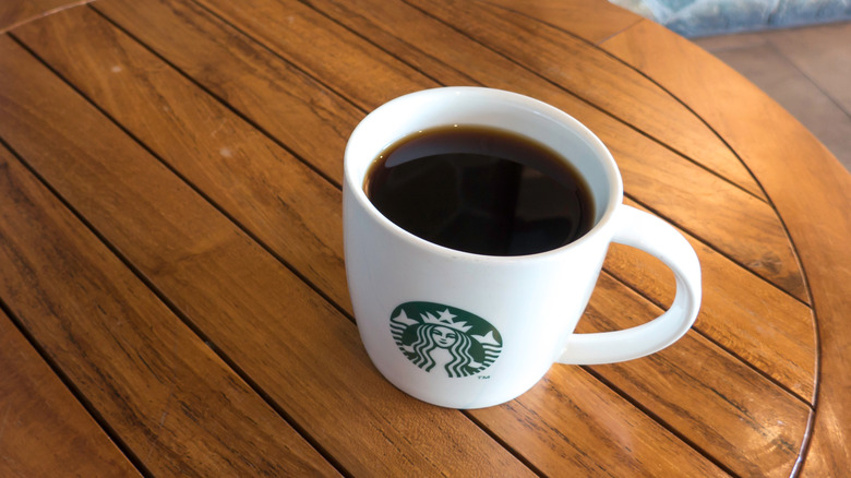 Starbucks mug of black coffee on table