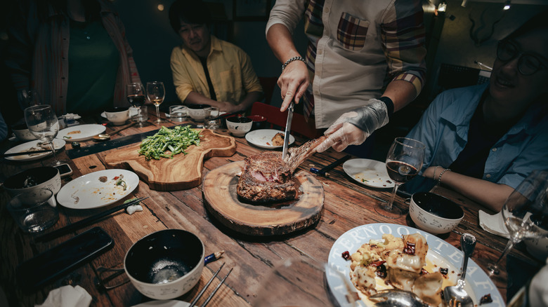 person cutting steak on table