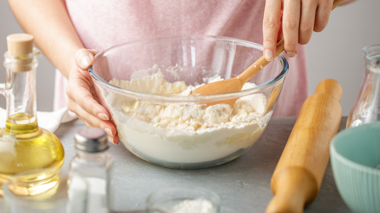 Woman mixing dry ingredients in bowl with spoon