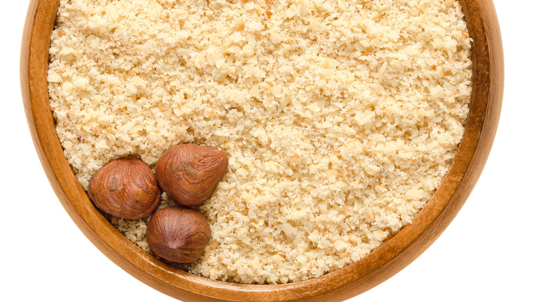 Hazelnut flour topped by three hazelnuts