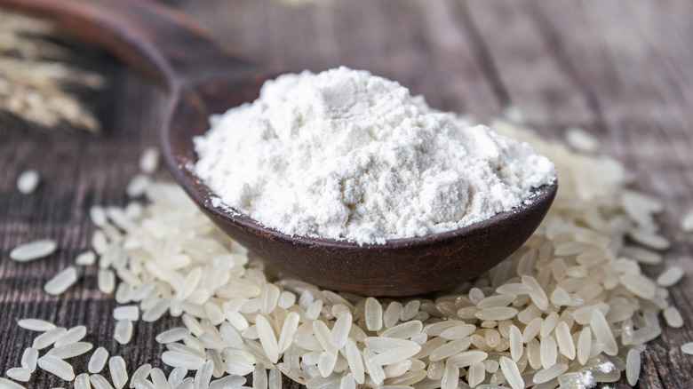 Rice flour in spoon on top of rice grains