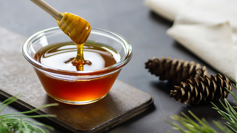 Bowl of honey with honeycomb spoon