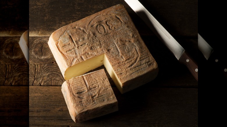 Taleggio cheese on wooden table with knife