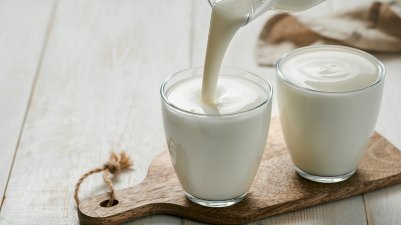 Buttermilk poured into a glass on wood block