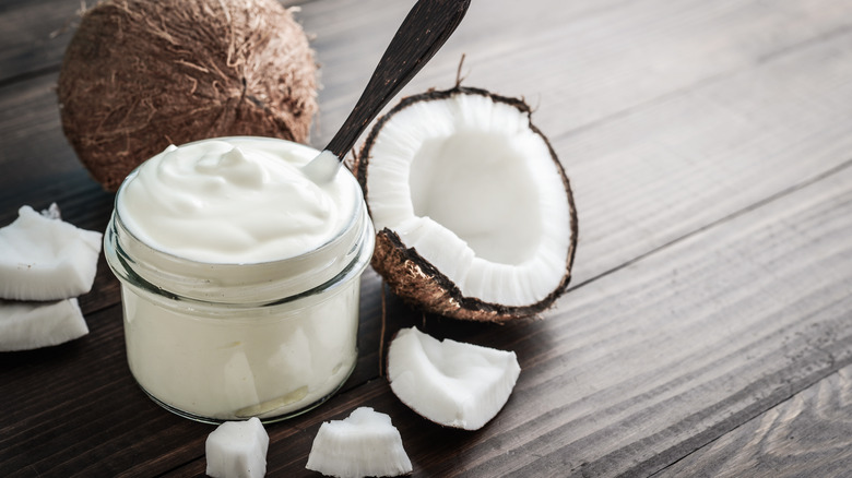 Coconut cream in jar next to raw coconut