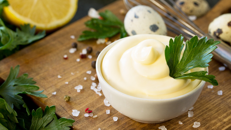 Mayonnaise in white bowl with leaf sprig