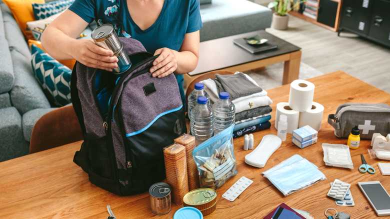 Woman packing survival backpack