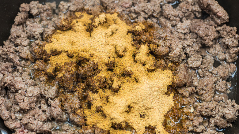 Cooking seasoned ground beef in a pan for Taco Bell Loaded Nacho Taco copycat recipe