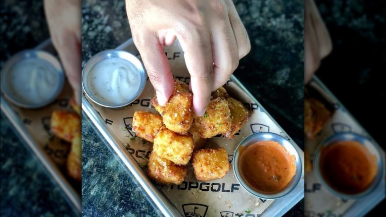 Hand grabbing topgolf macaroni bite