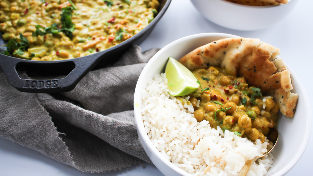 Chickpea curry with naan, rice and limes