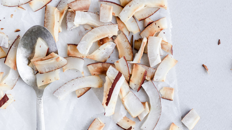 toasted coconut flakes with a spoon