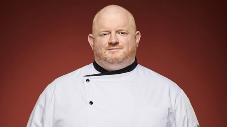 Contestant Declan in chef's coat on red background