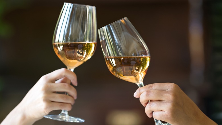 Two people toasting wine glasses