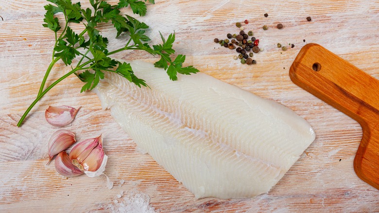 halibut near cutting board and peppercorn