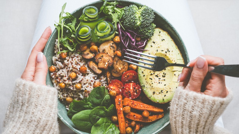 hands holding vegan bowl