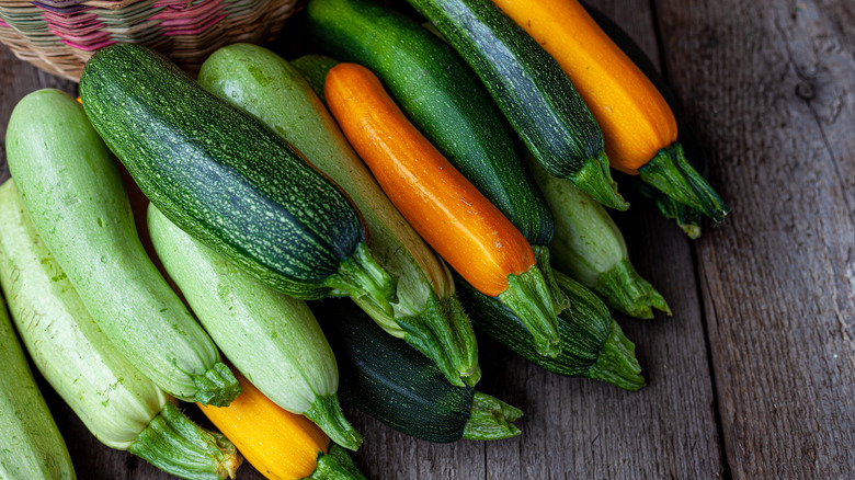 A bunch of colorful zucchini on a table.