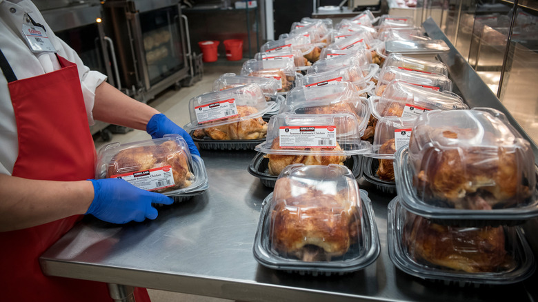 Costco worker packaging rotisserie chicken