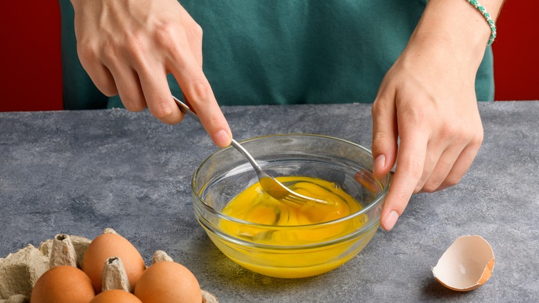 whisking eggs in glass bowl