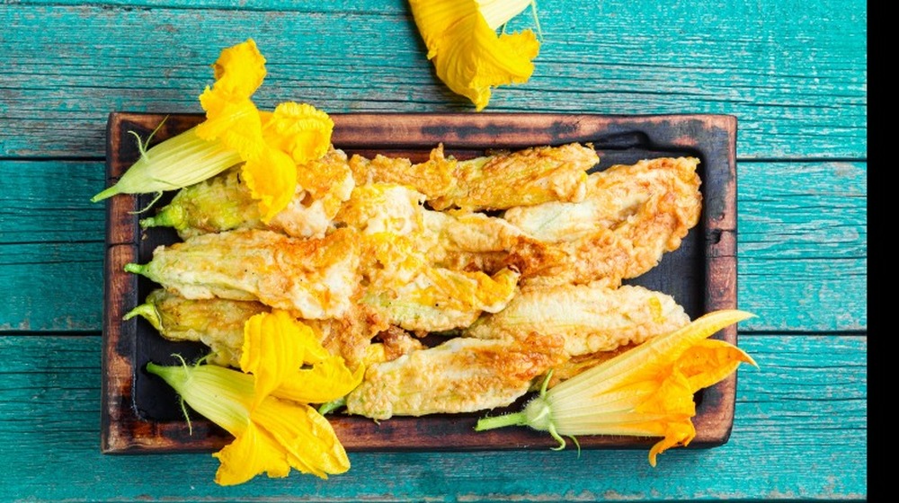 Fried zucchini blossoms on a brown plate