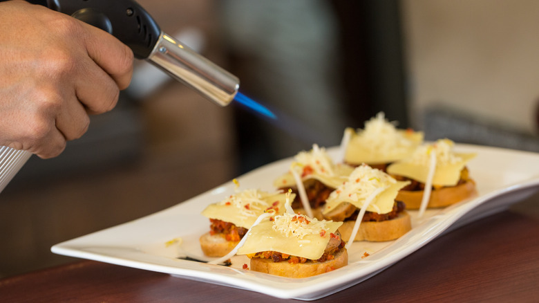 Kitchen Torch with Cheese on Bread Slices