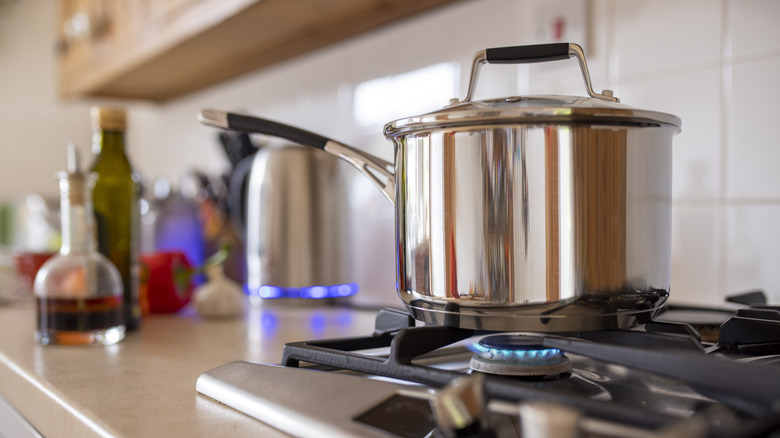 A silver pot on low heat on a stovetop. 