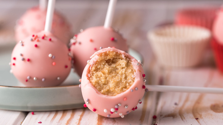 Cake pops with pink icing and silver, white, and red sprinkles