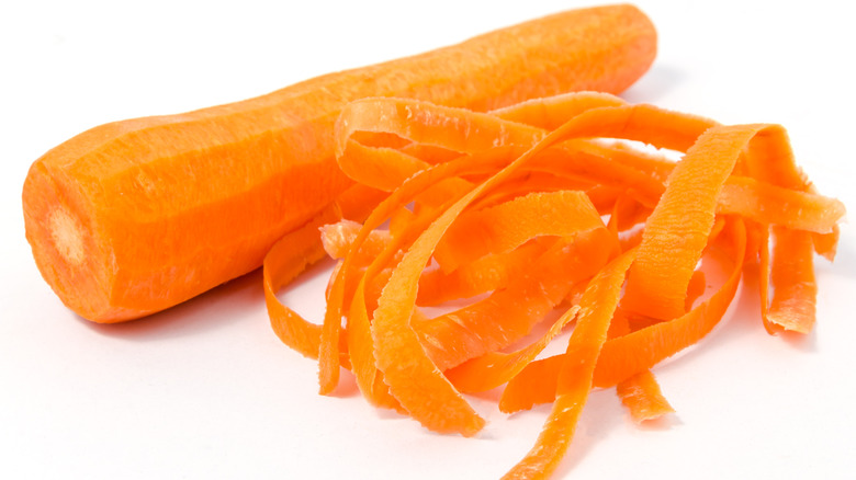 A peeled carrot next to peels