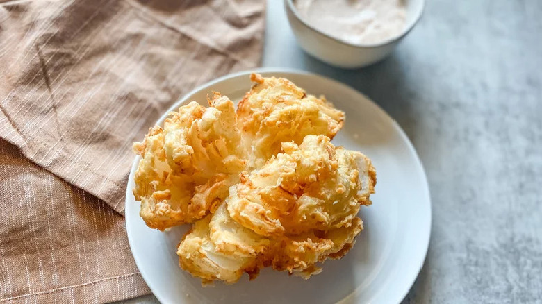 fried onion blossom on white plate