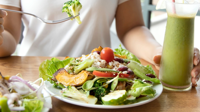 Large salad by a green smoothie