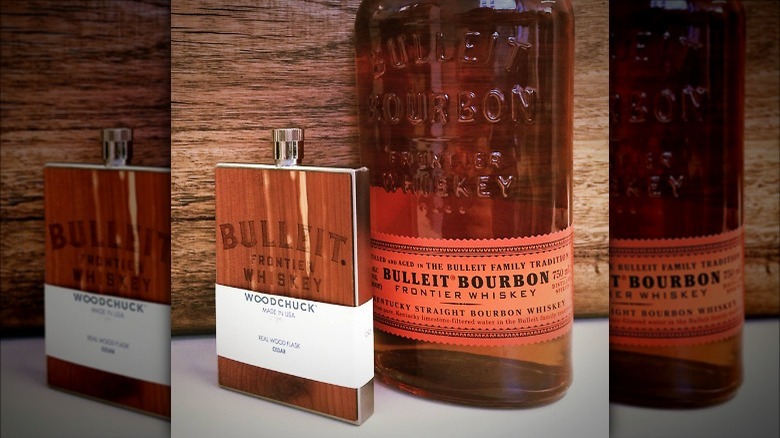 Bulleit bourbon bottle and wood flask