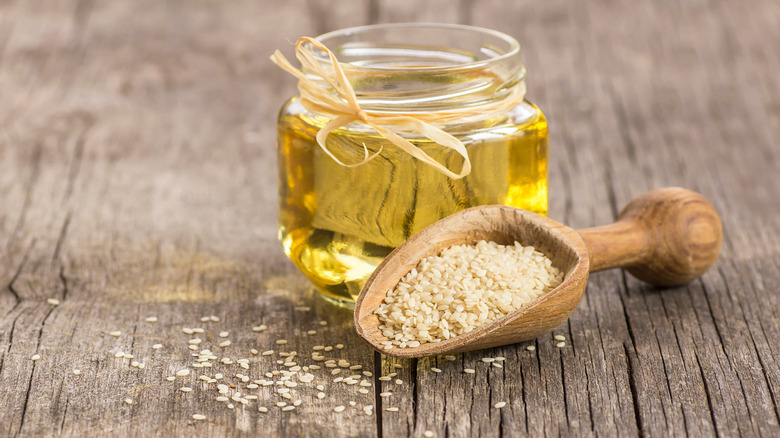 sesame seeds and oil on a wooden table