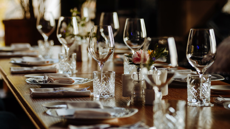 An ornately set table with wine glasses