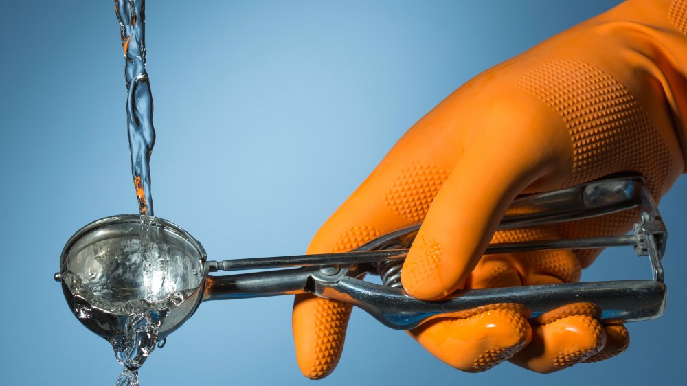 Ice cream scooper with water pouring onto it