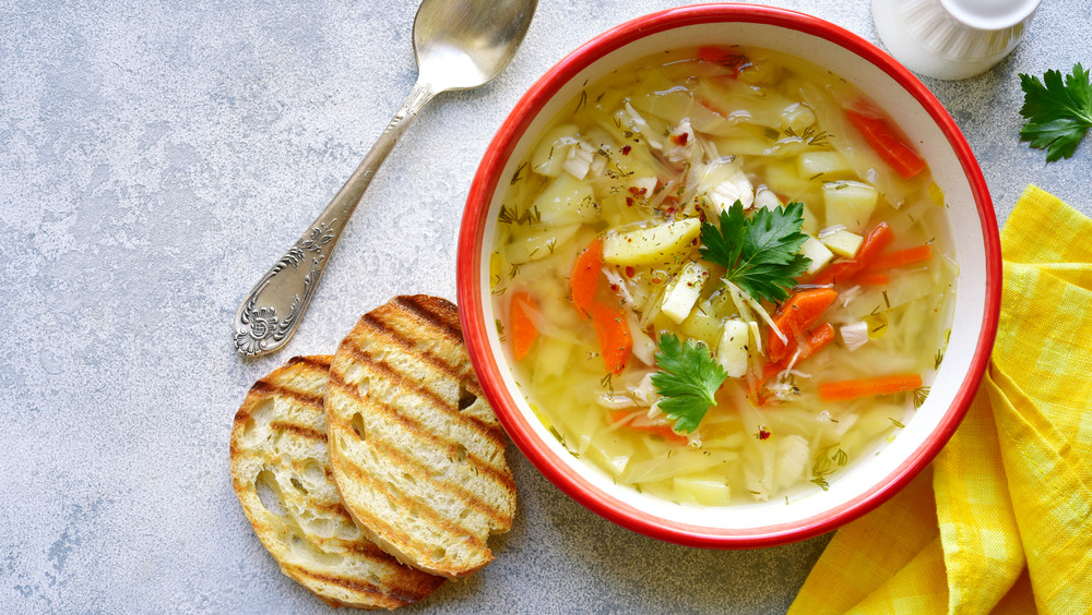 Cabbage soup in a bowl with sliced toast