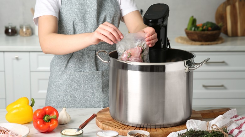 Person placing food in sous vide cooker