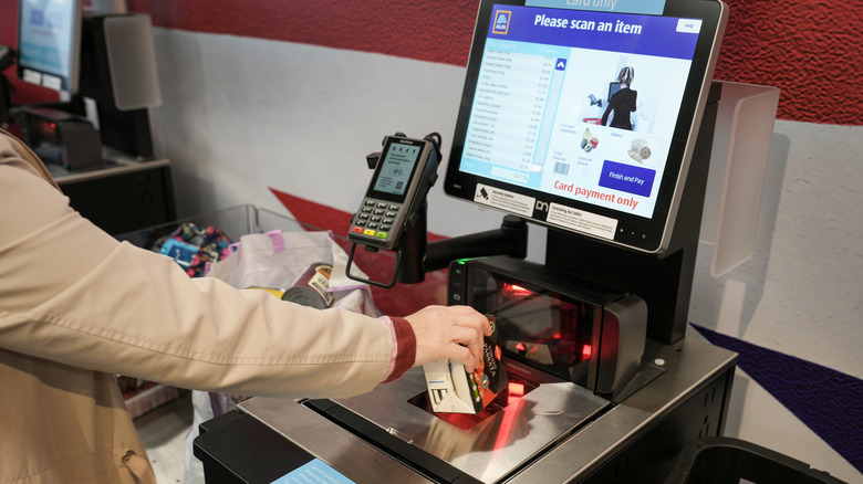 A customer uses a self-checkout terminal at the Tarleton Aldi store in the UK