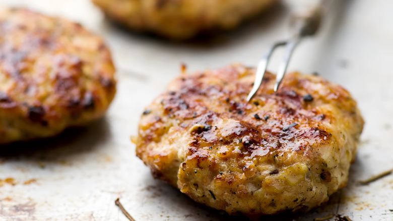 A chicken burger patty on a baking sheet