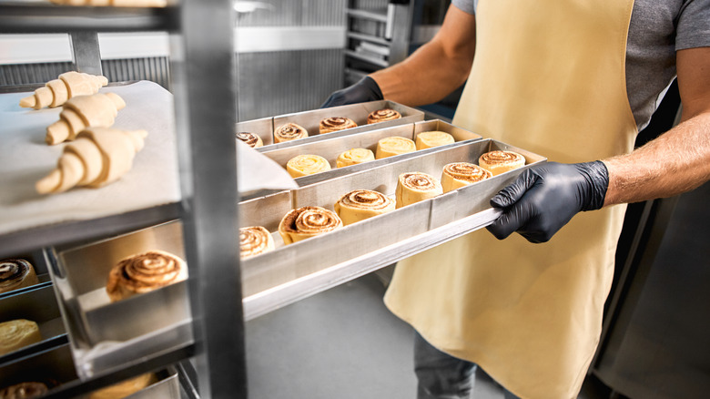 Removing tray of unbaked cinnamon rolls from shelf