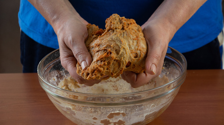 Two hands kneading seitan