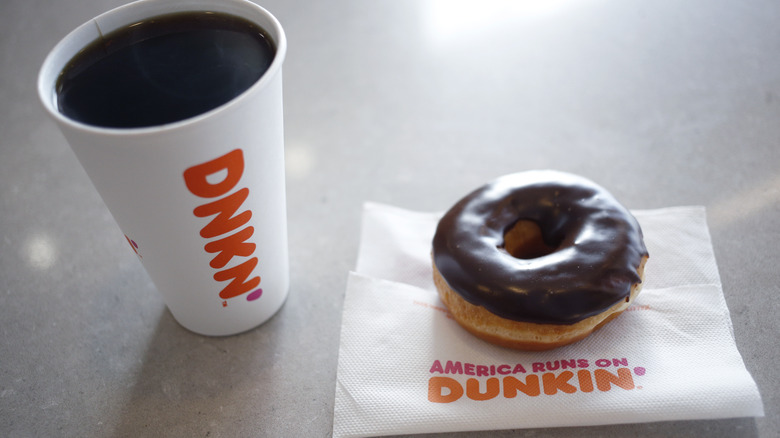 Dunkin coffee next to chocolate donut