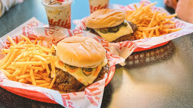 freddy's triple burger in hand