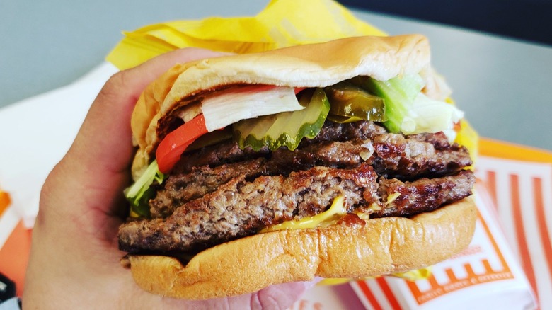 hands holding Triple Meat Whataburger