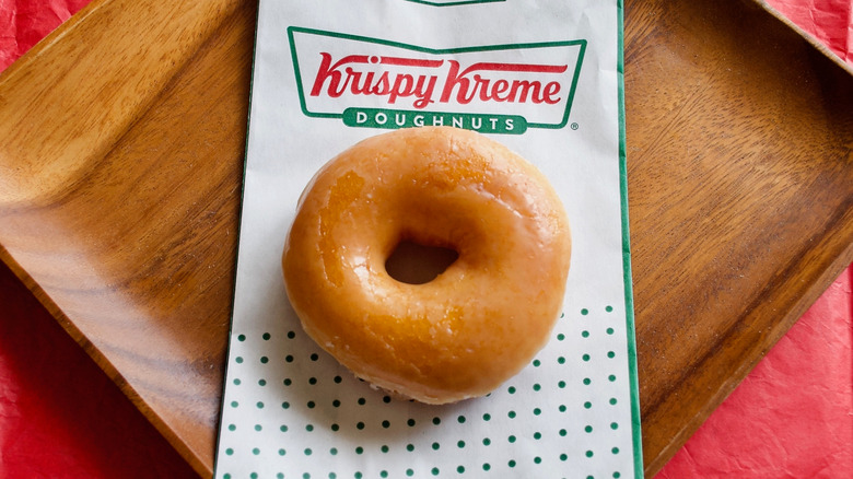 krispy kreme donut on wood tray