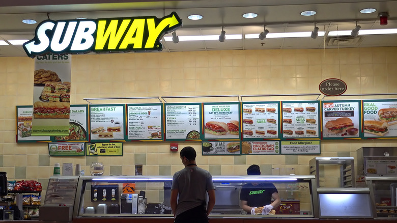 Customer examines Subway menu