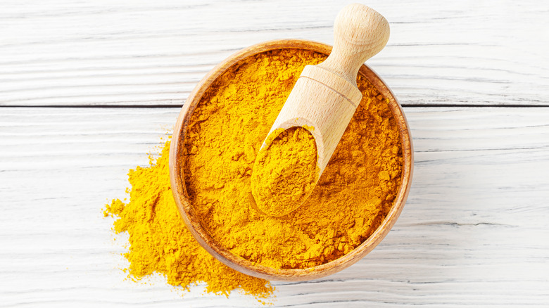 bowl of turmeric powder with scoop