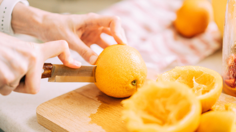 Woman cutting orange fruits