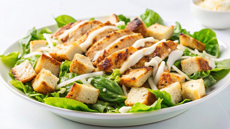 Caesar salad topped with chicken