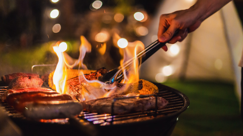 Person grilling meat outside