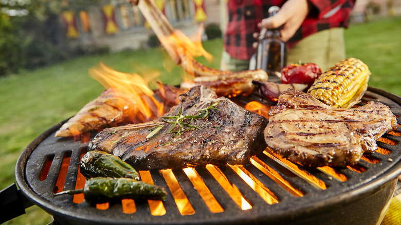 Person grills meat and vegetables