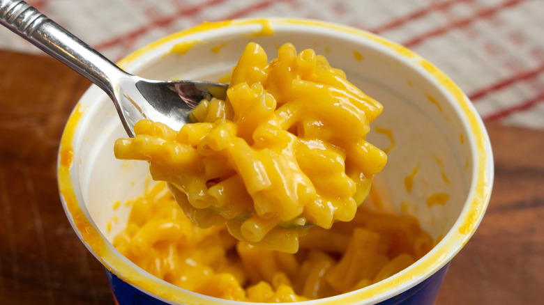 A bowl of warm mac and cheese hoisted by a spoon